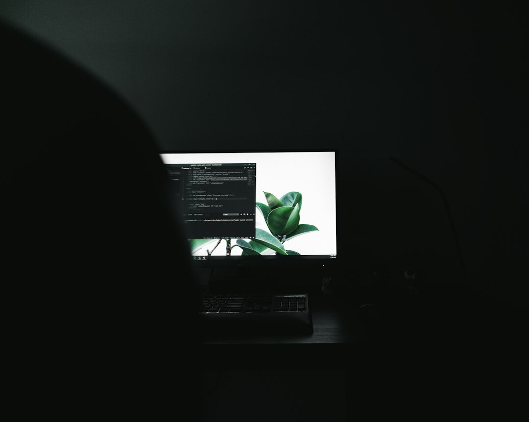 Software developer writing code on dual monitors