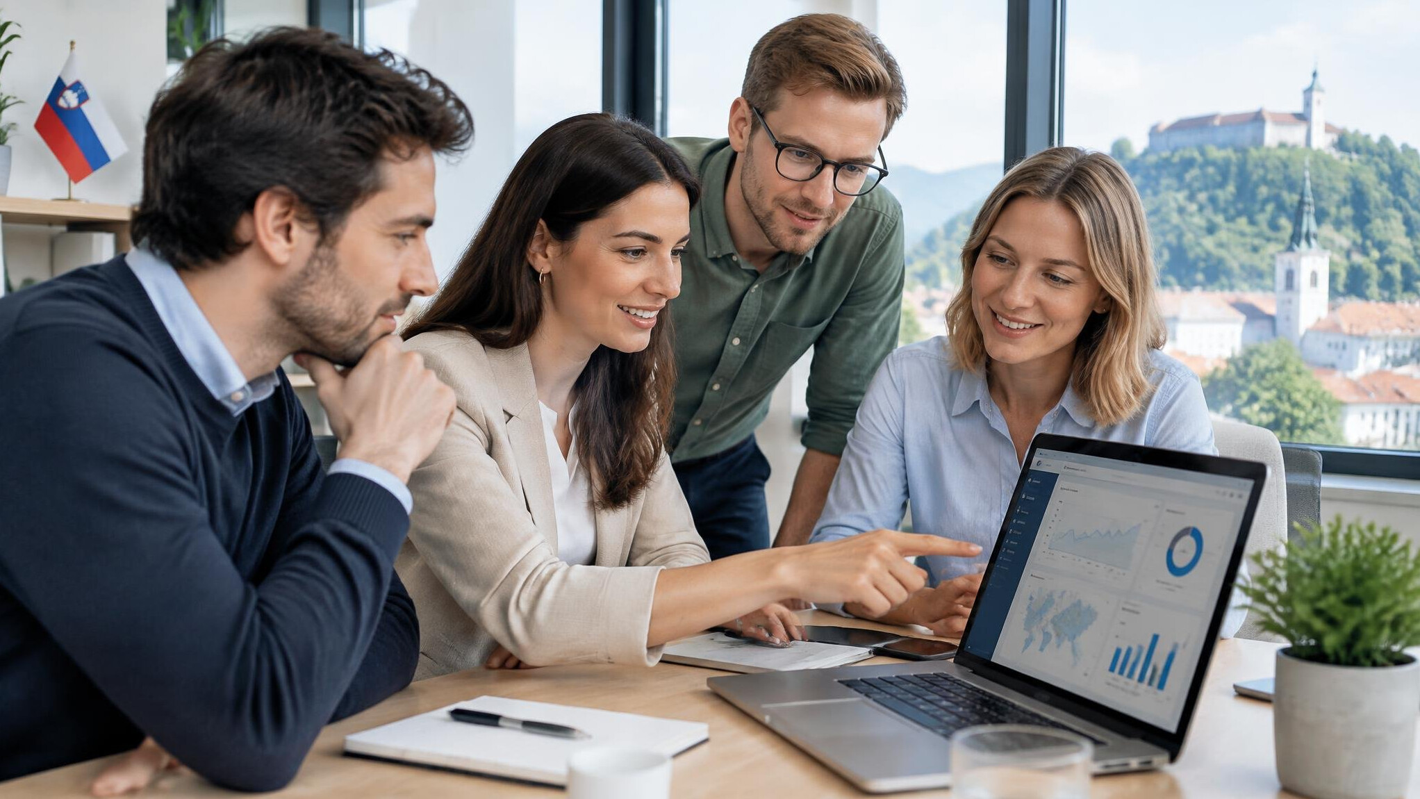 Team of business professionals collaborating around a laptop discussing a software project
