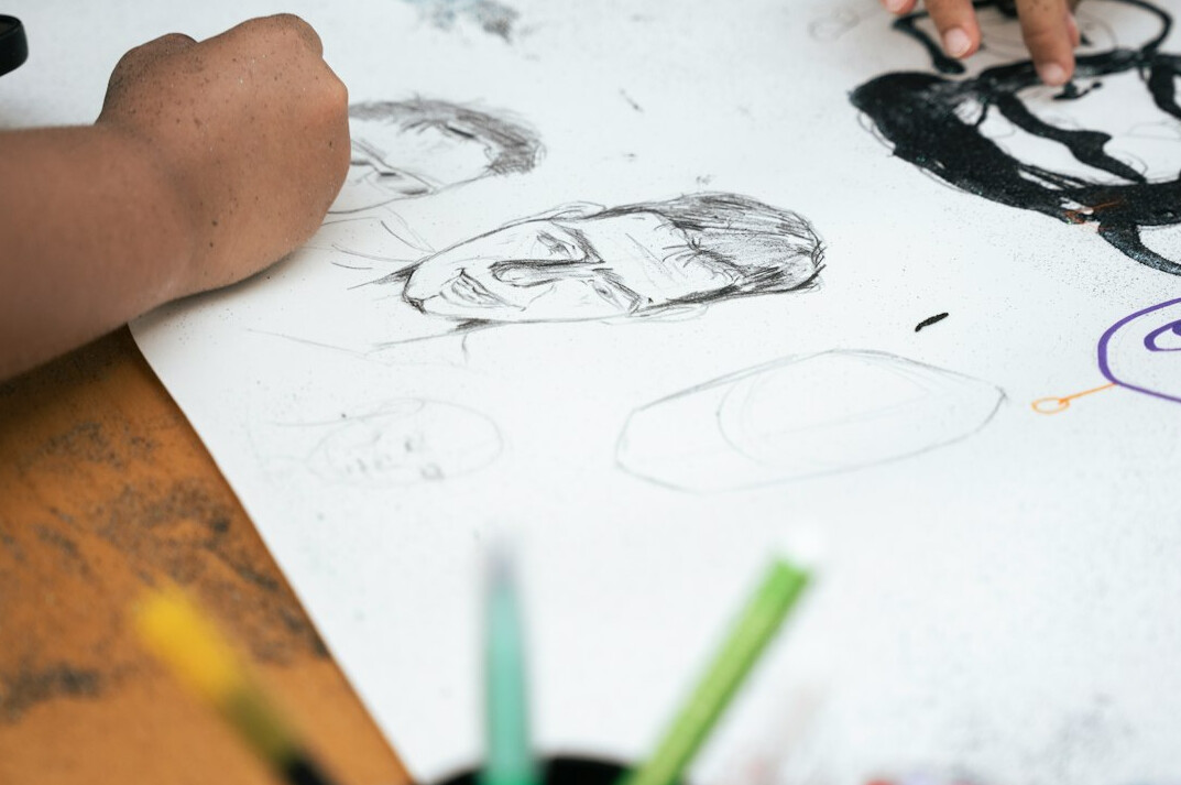 Close-up of hands sketching a workflow diagram on paper